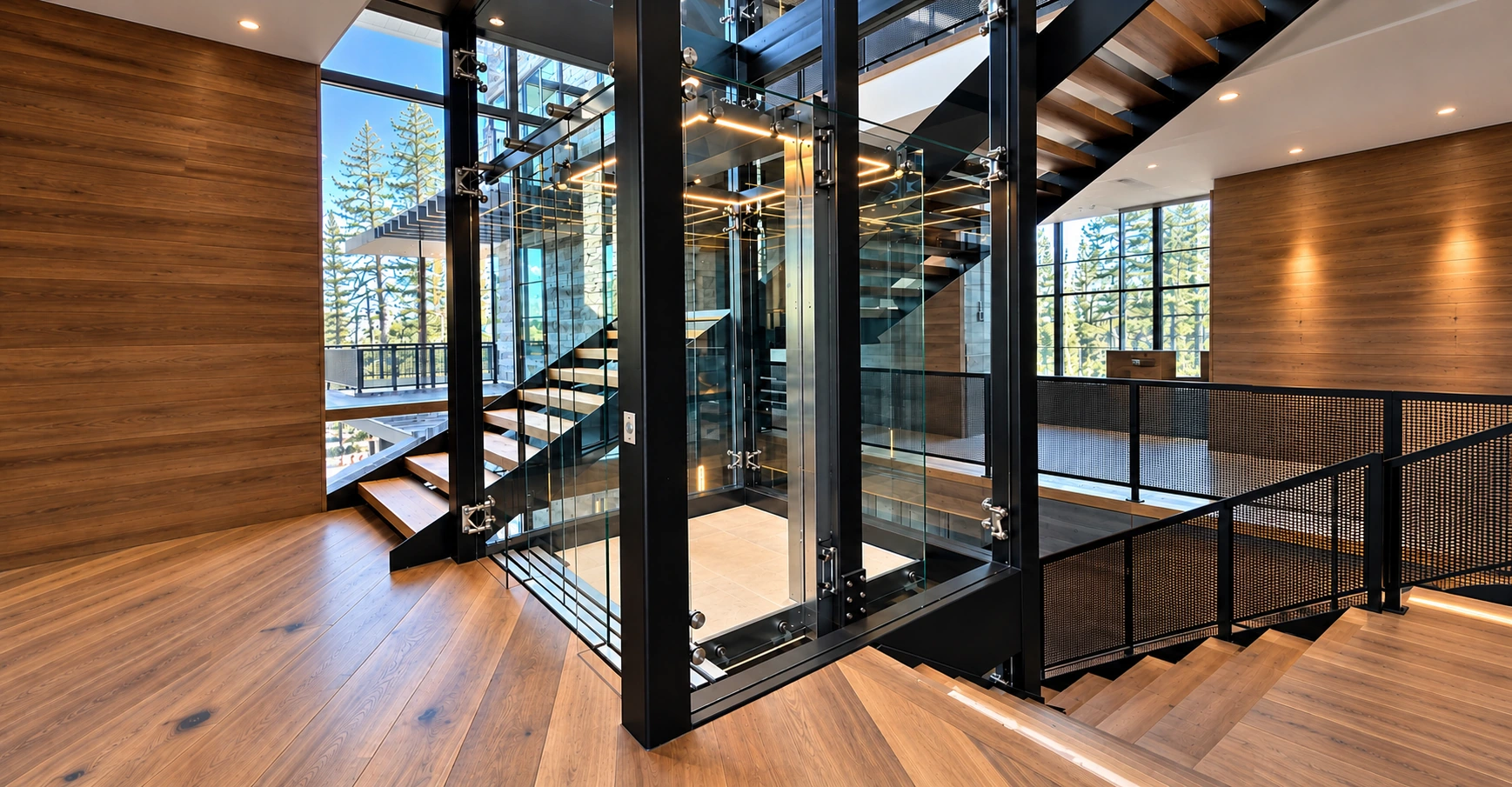 Custom glass elevator with black steel framing beside timber stairs in a luxury home.